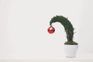 A holiday tree bends with stress from a heavy ornament