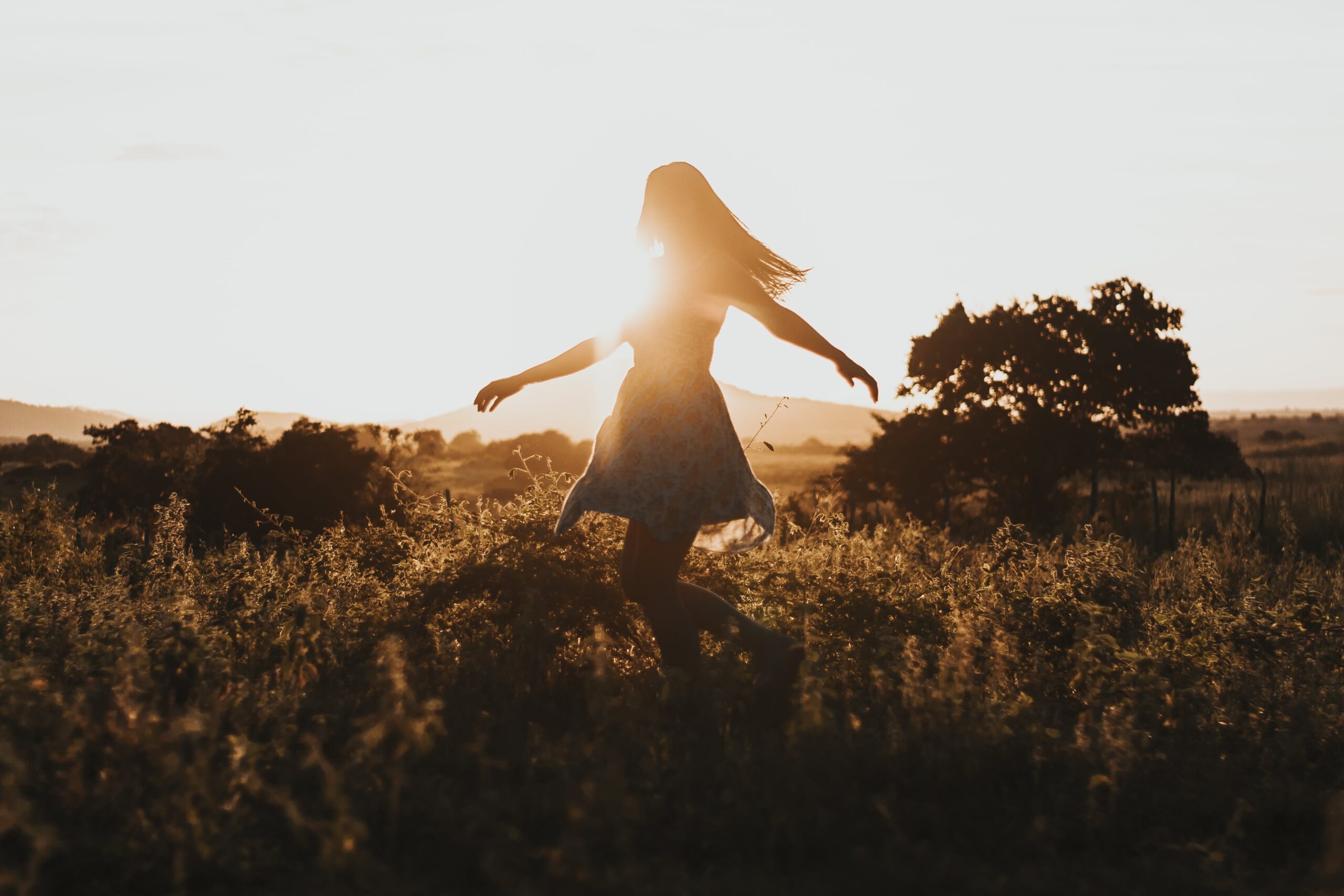 woman walking through a field, embrace preconception wellness