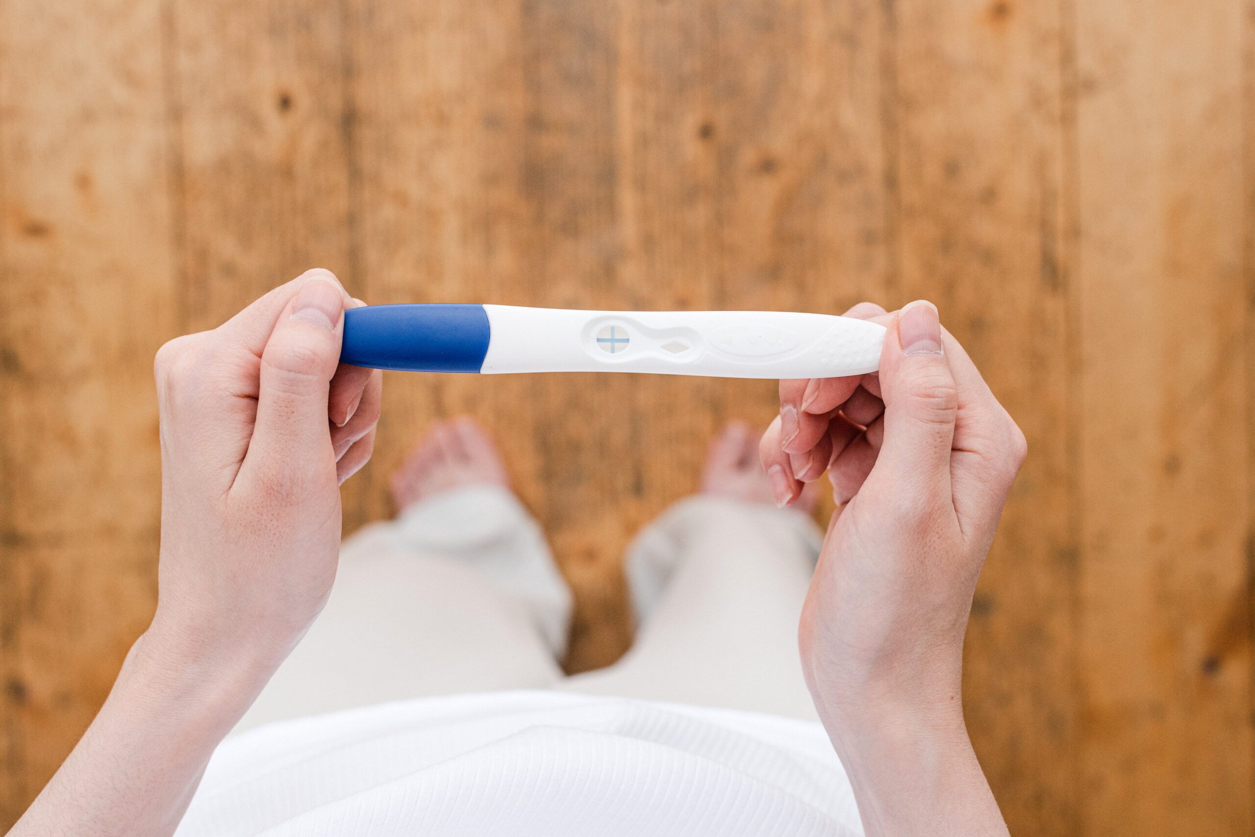 A woman holding a positive pregnancy test. 