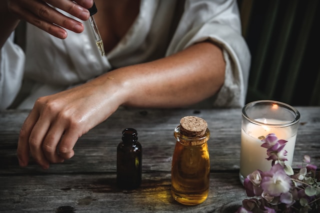 A woman applying essential oils while relaxing with a candle. Brookfield prenatal chiropractor Prenatal chiropractor Brookfield pediatric chiropractor