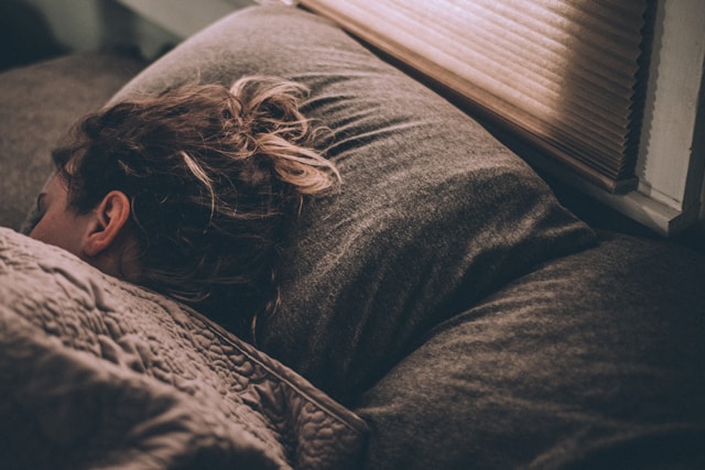 A woman sleeping in a bed with her hair splayed on the pillow. Brookfield prenatal chiropractor Prenatal chiropractor Brookfield pediatric chiropractor