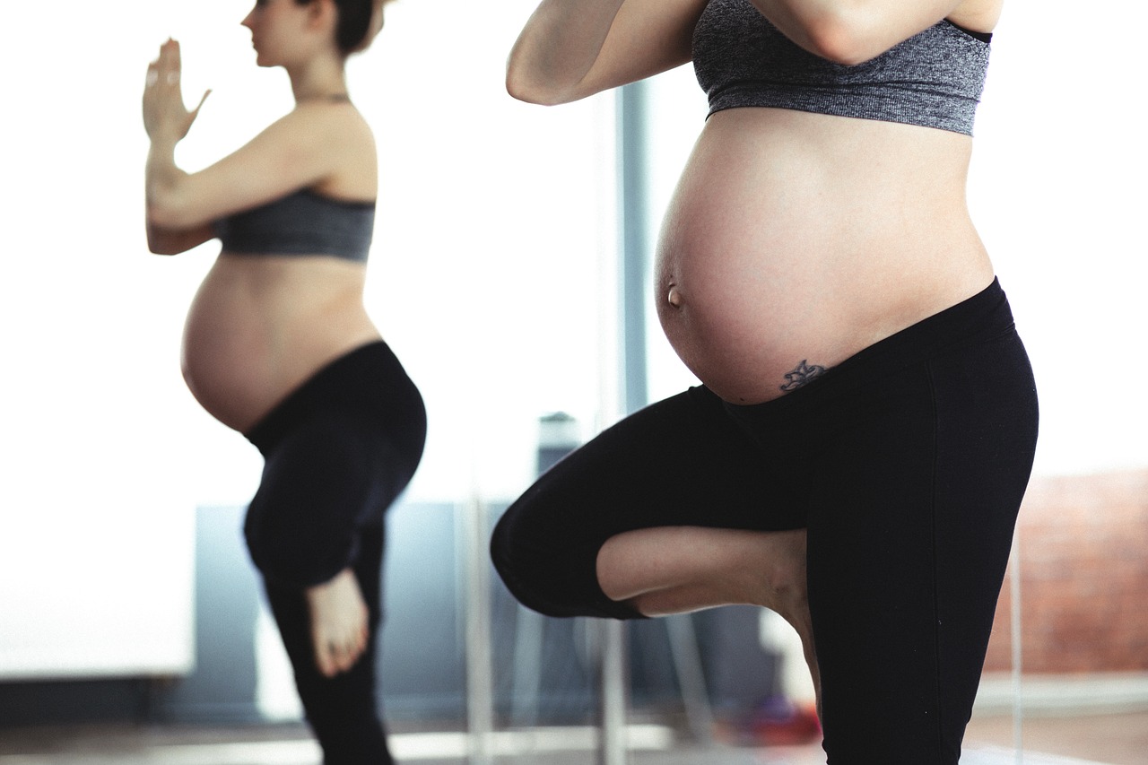 Pregnant woman doing tree pose in yoga