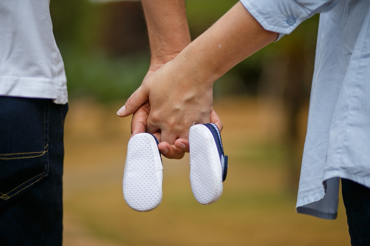 Mom and dad holding baby shoes