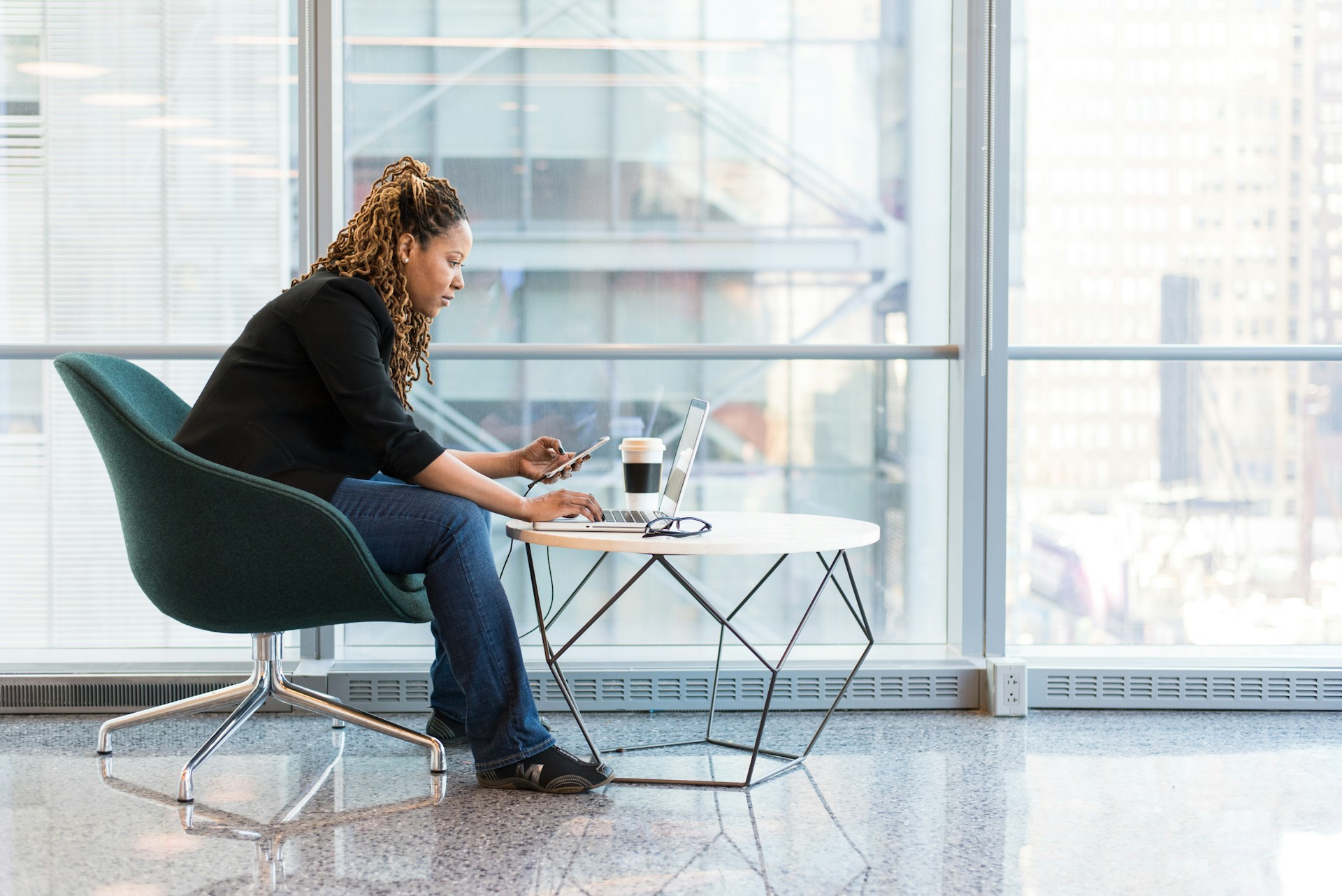 Woman sitting on chair hunched over computer with poor posture