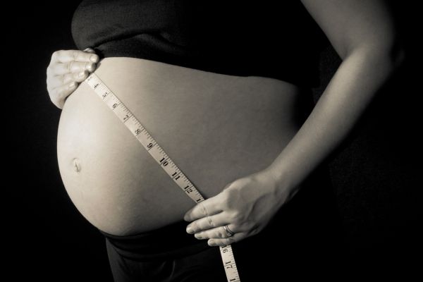 Woman measuring her baby bump 