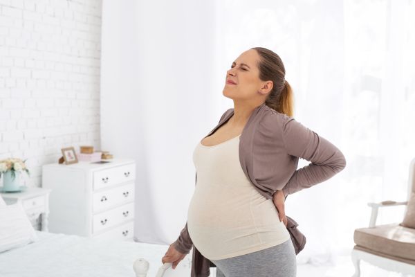 Pregnant woman stretching because of back pain